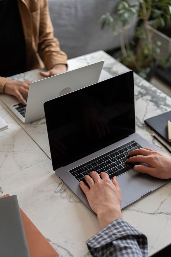 Mastering the First Impression: Your intriguing post title goes here Two people working on laptops in a modern office setting, showcasing teamwork and productivity.
