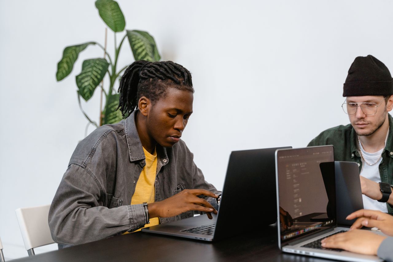 Crafting Captivating Headlines: Your awesome post title goes here Two young adults working together on laptops in an office setting, focusing on tasks.